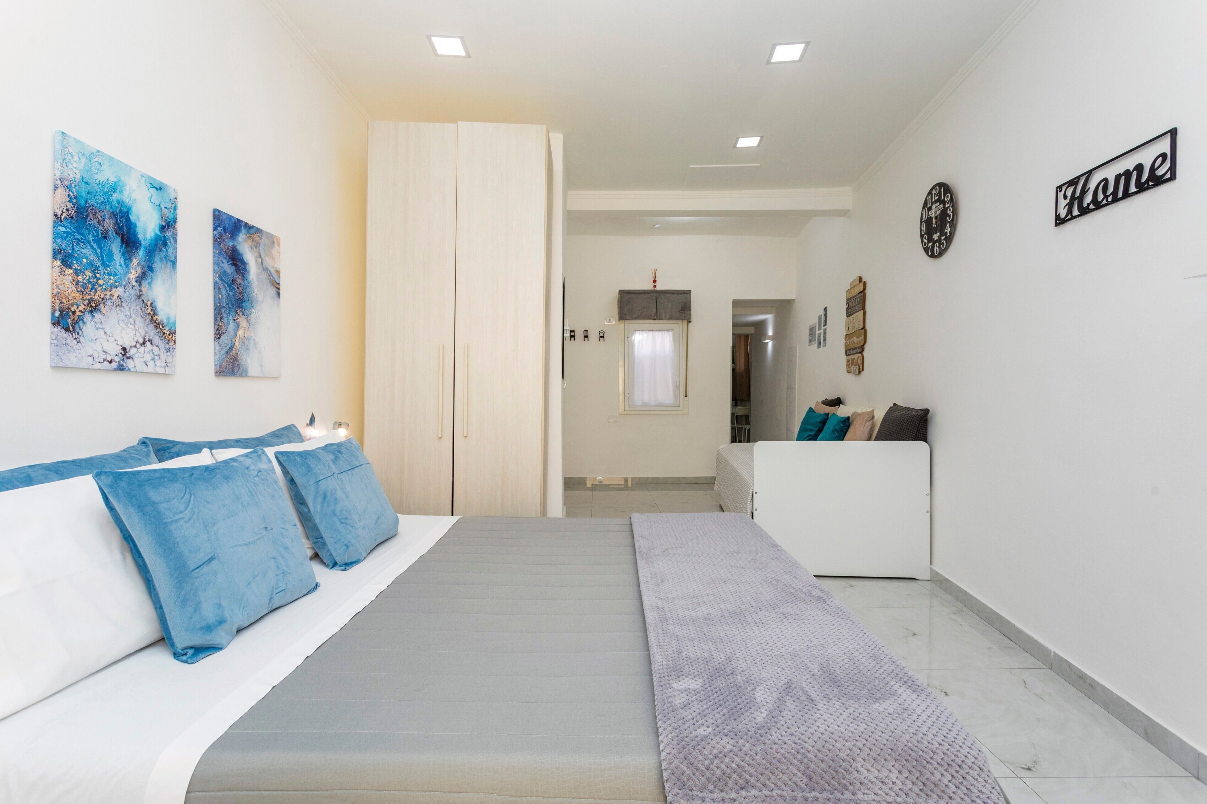 Ein Schlafzimmer mit Bett, Kleiderschrank, Nachttisch und Wanduhr.