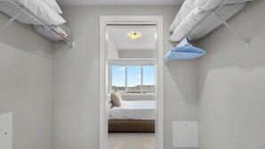 Un dormitorio con cama, ventana y ventilador de techo.