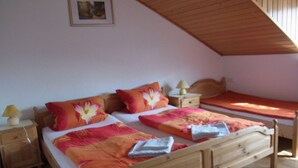 Un dormitorio con dos camas de madera, cada una con una mesita de noche y una lámpara.