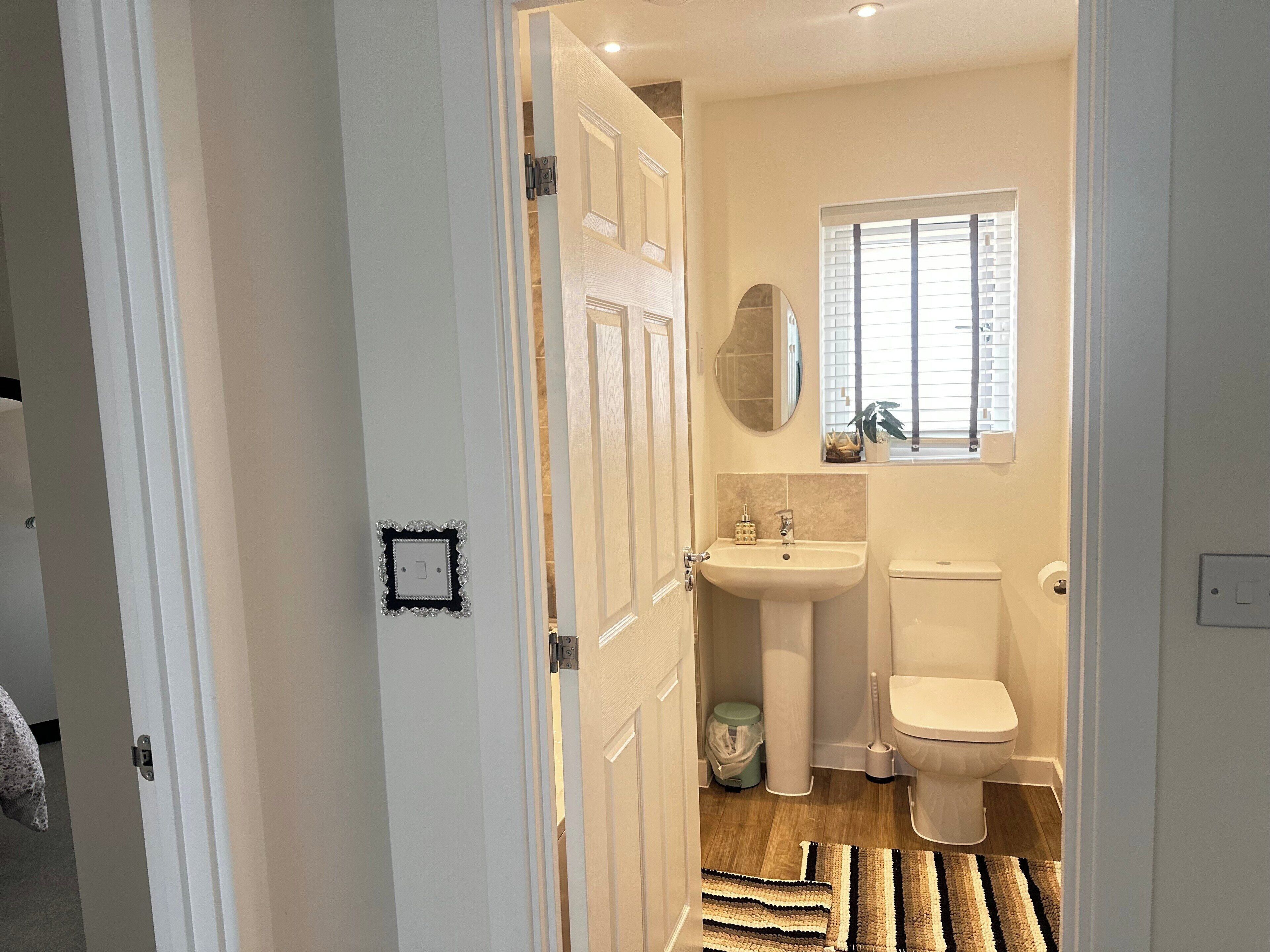 Une salle de bain avec des toilettes, un lavabo et une fenêtre.