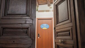 Una puerta de madera con un letrero que dice 'Napoli Tano Rooms'.