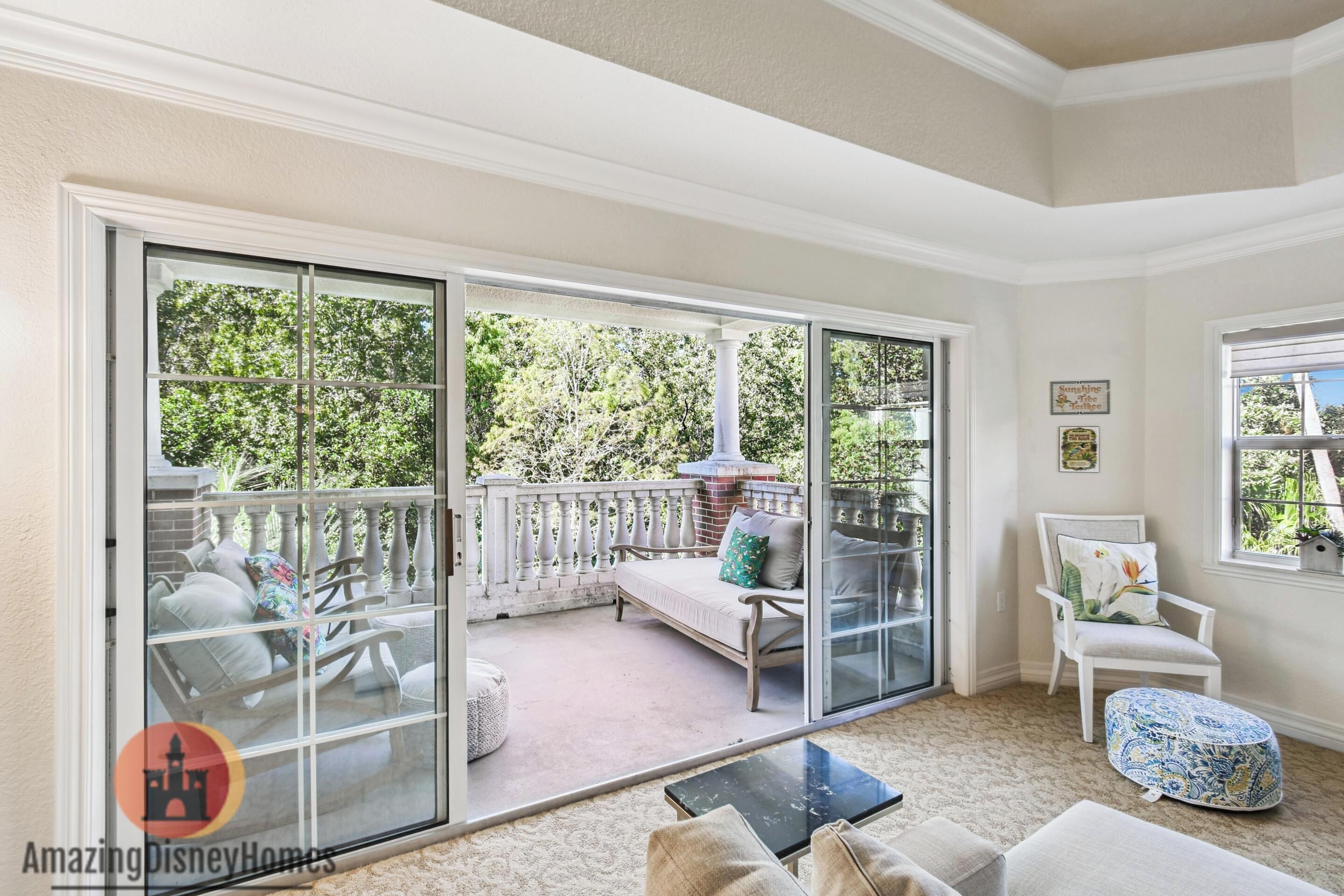 Ein Zimmer mit einer großen SchiebeglasTür, die auf einen Balkon mit Gartenmöbeln führt.