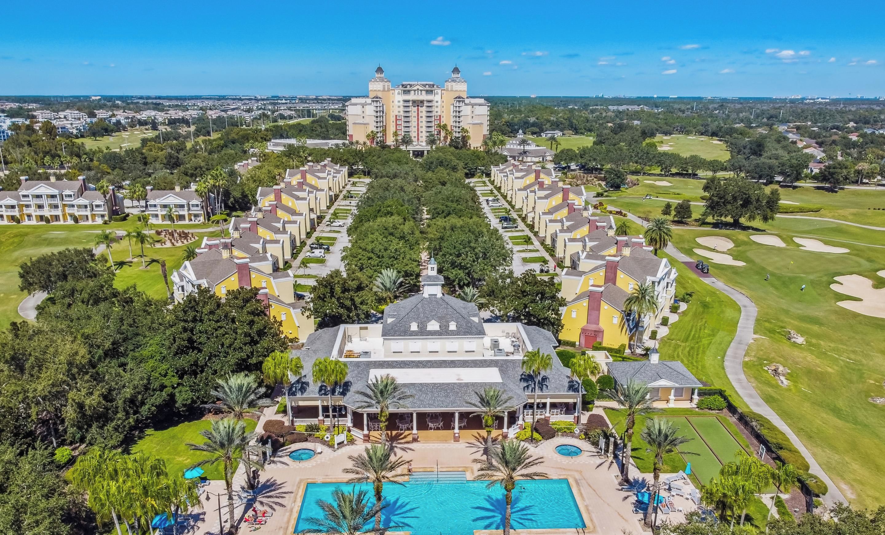 A resort with a central pool, multiple guest buildings, and a golf course.