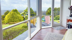 Una habitación amplia con puertas de cristal que dan a un jardín.