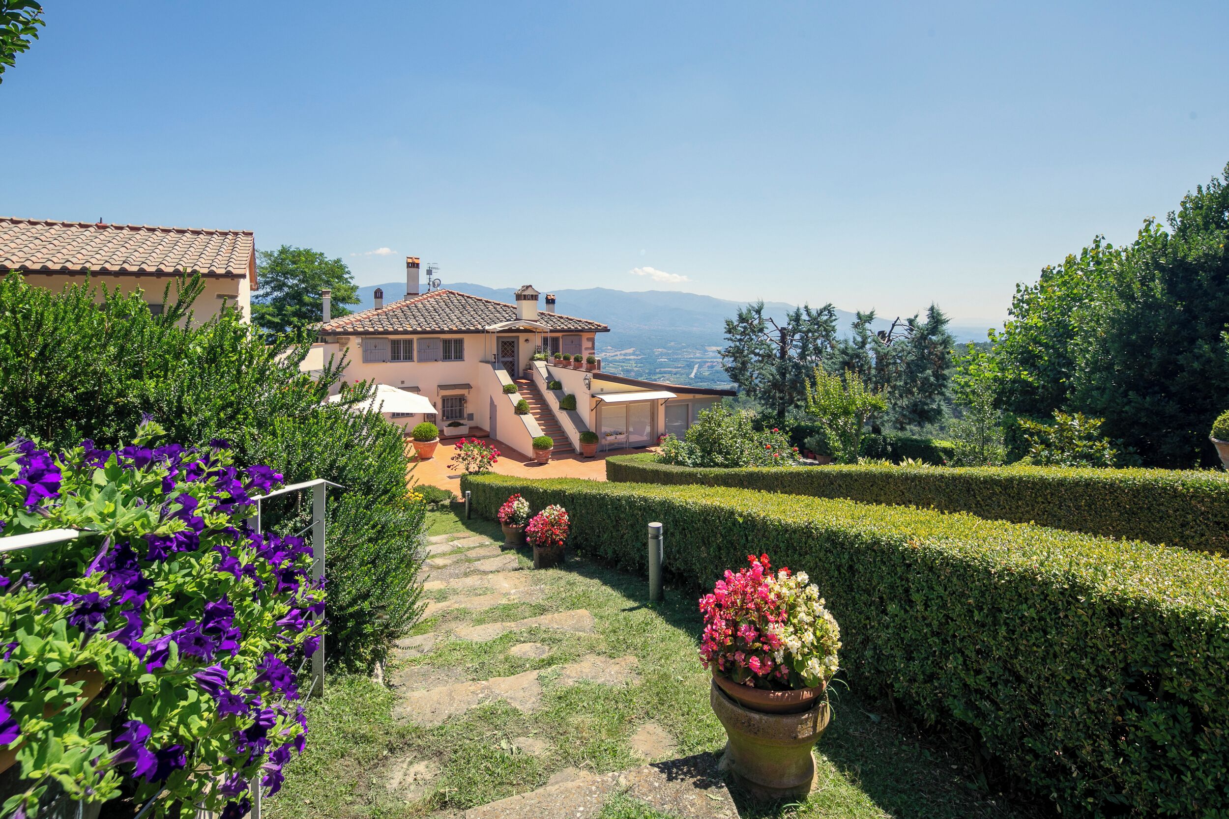 Una casa con un sendero de jardín que conduce a una terraza.