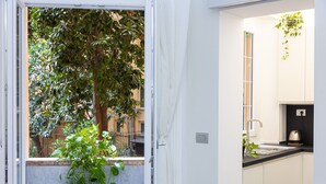 Una cucina moderna con finestra, mobili bianchi e un piano di lavoro nero.
