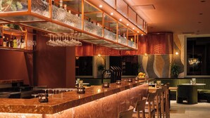 A bar area with a long counter, multiple seating options, and a decorative wall.