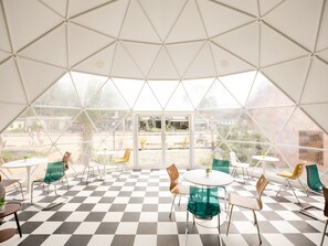 A spacious, geometrically designed interior with checkered flooring, multiple seating areas, and large glass windows offering views of the outside. - L1 Lanta Resort (Ko Lanta)