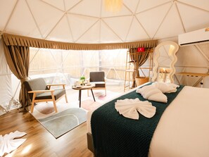 A tent-style room with a bed, two chairs, a small table, and a large mirror. - L1 Lanta Resort (Ko Lanta)