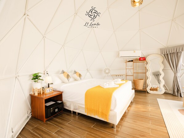 A tent-style room with a bed, bedside table, lamp, and a small plant. - L1 Lanta Resort (Ko Lanta)