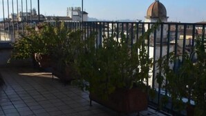 A rooftop terrace with tiled flooring, potted plants, and a metal railing. - hotel cordova (Florence)