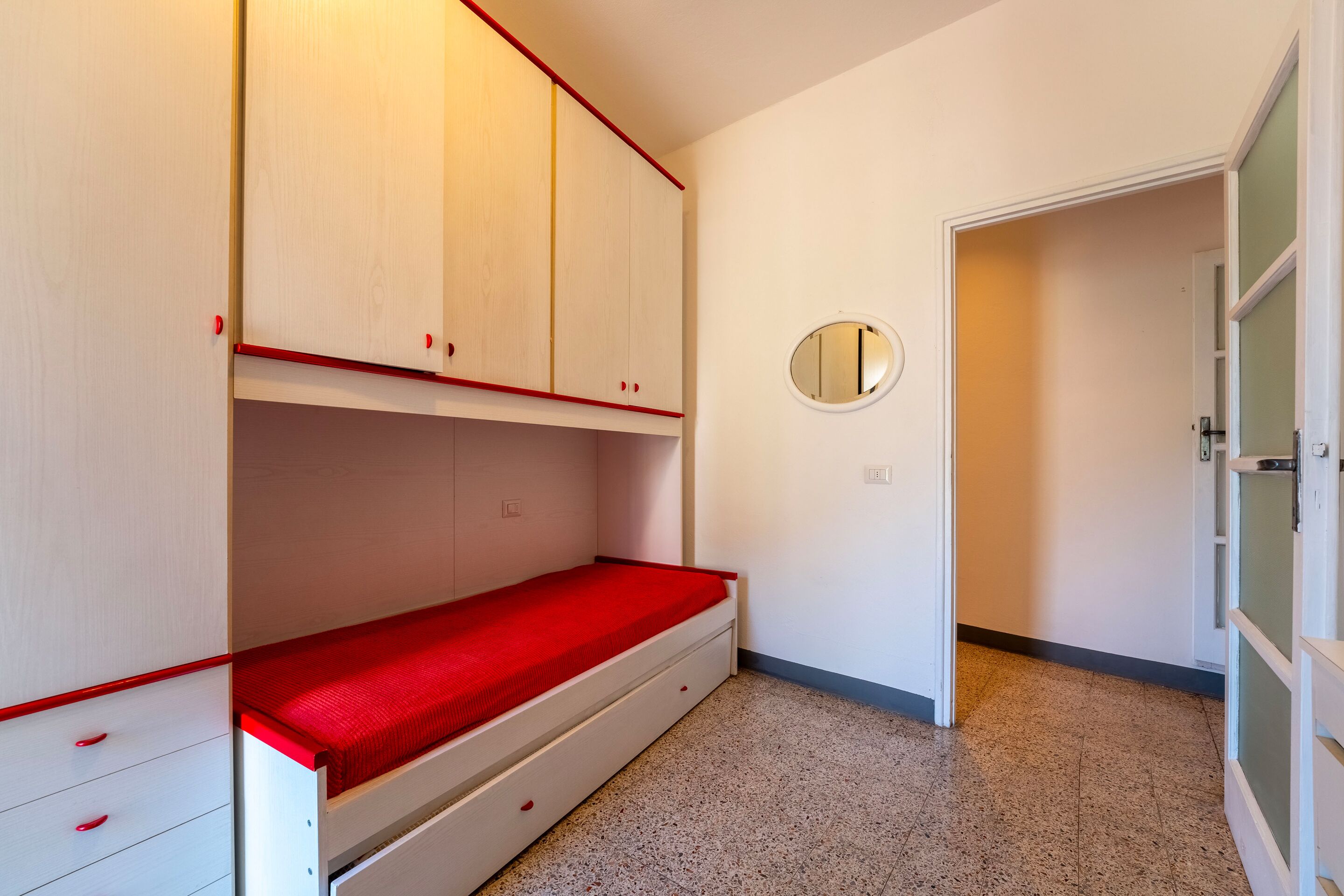Ein Schlafzimmer mit Etagenbett, einem Einzelbett und einem Kleiderschrank.
