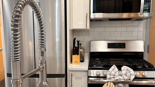 A kitchen with white cabinets, stainless steel appliances, and a speckled ceramic container with wooden utensils. - Downtown 3BR Home with 2 Baths, Kitchen & W/D (Providence)