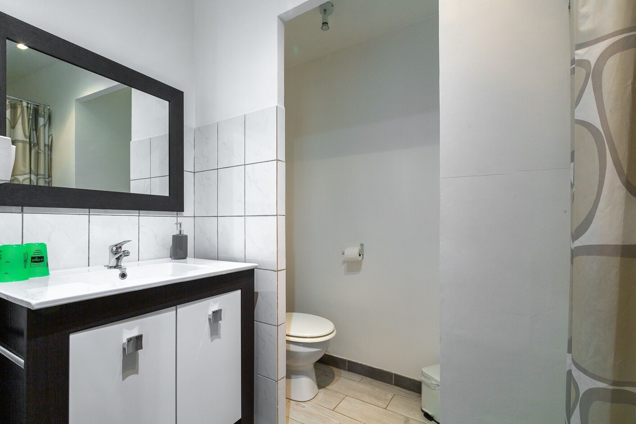 A bathroom with a white sink, mirror, and toilet.