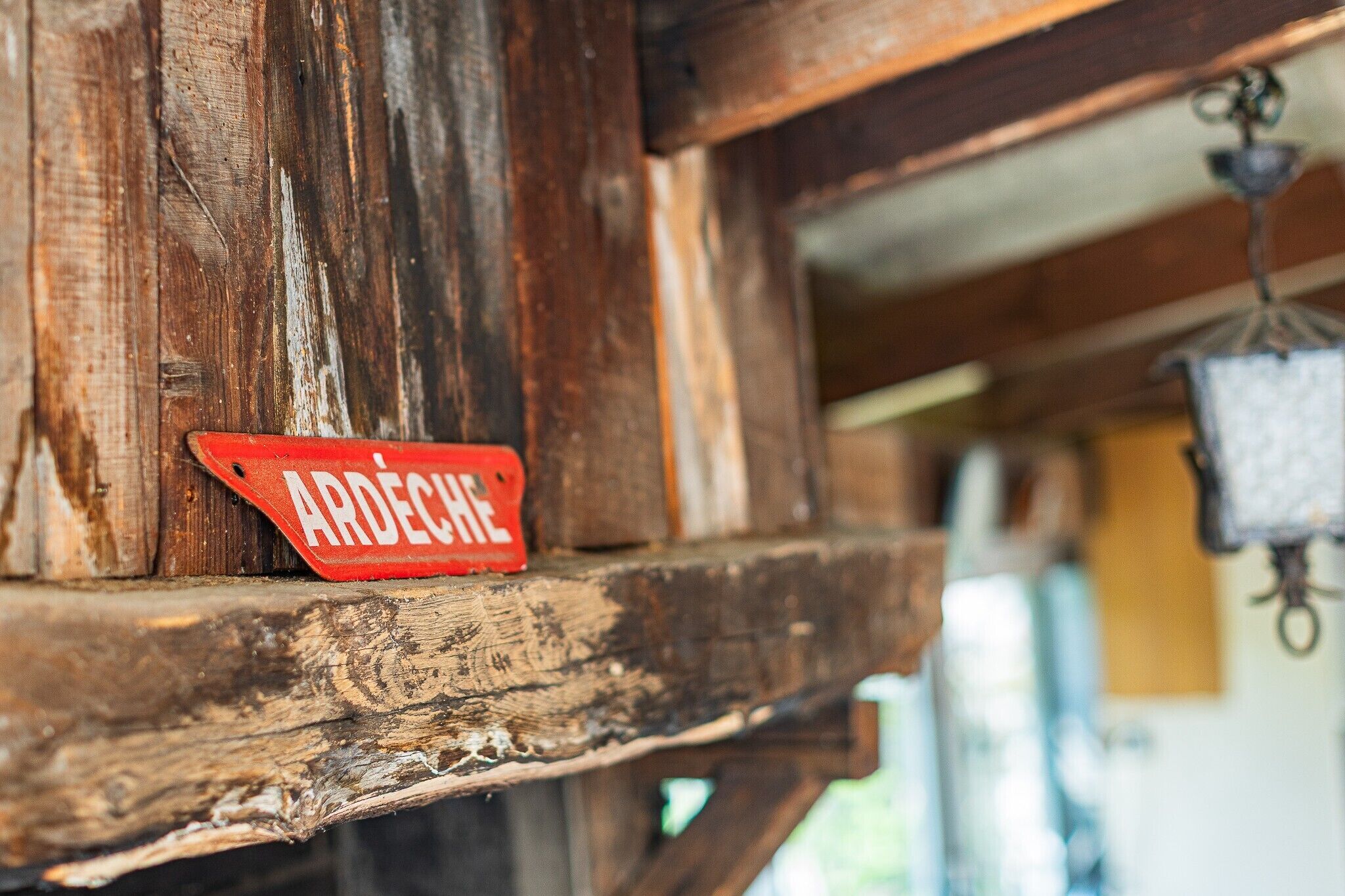 Una struttura in legno rustica con un cartello rosso che riporta la scritta 'ARDECHE'.
