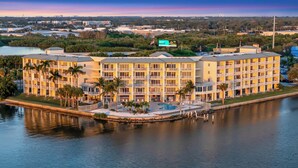 A multi-story hotel with a pool and waterfront view, featuring balconies and a flag. - Bay View Condo & Private Balcony | Pool & Hot Tub (St. Petersburg)