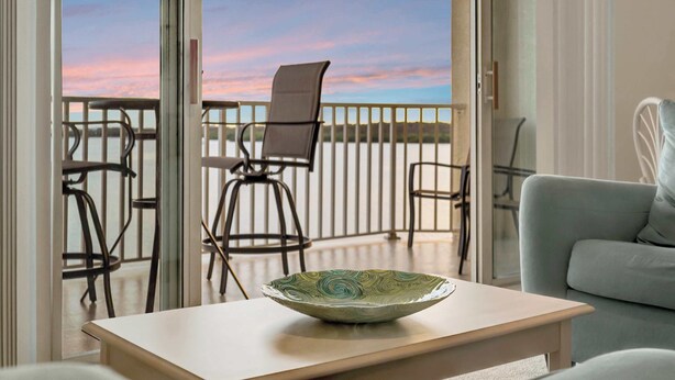 A modern living room with a view of the balcony and a table with a decorative bowl. - Bay View Condo & Private Balcony | Pool & Hot Tub (St. Petersburg)