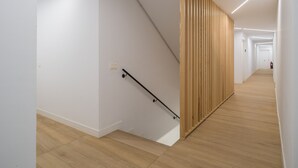 A modern interior with a wooden staircase, white walls, and a long hallway with wooden flooring. - Sunset Arguineguin by CanariasGetway (Mogán)