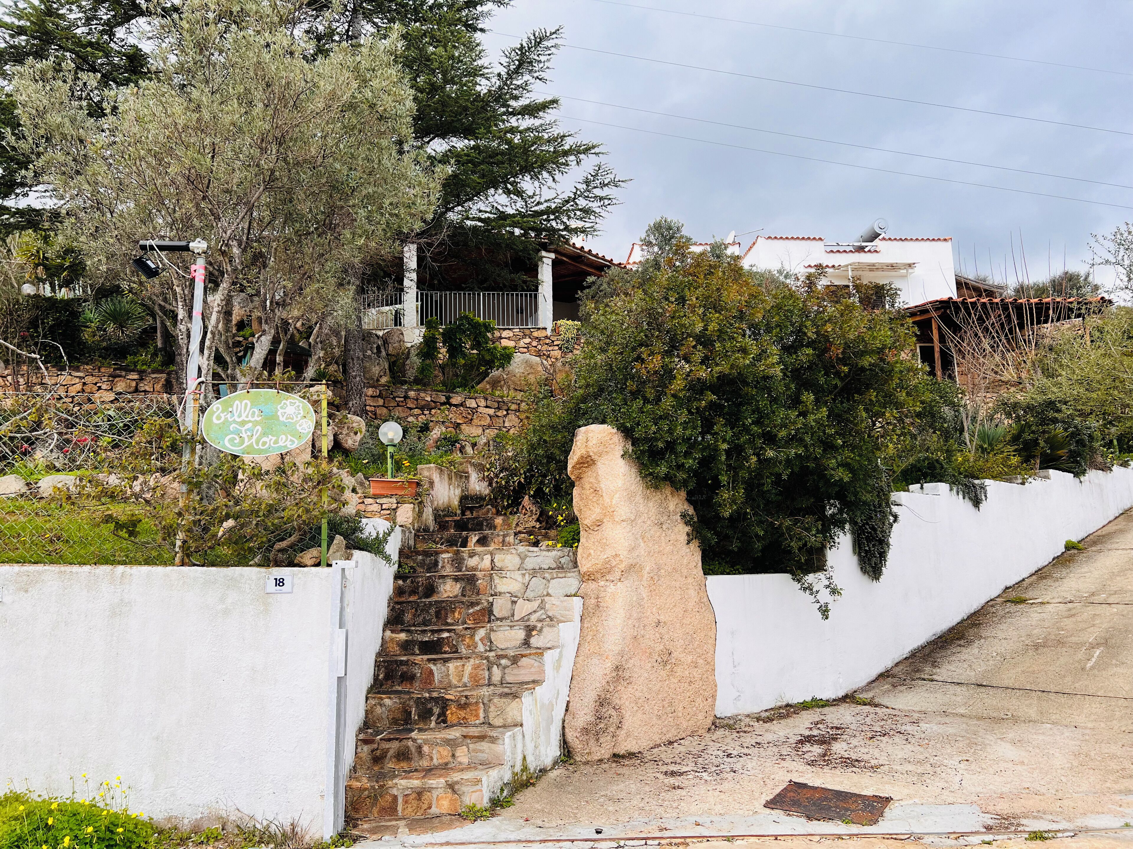 A stone staircase leading up to a white building with a sign reading "Ella Flora".