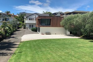 A modern two-story house with a well-maintained lawn and a driveway leading to the front door.