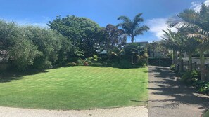 A well-maintained lawn with a gravel path leading to a gated entrance.