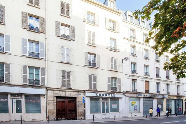 A multi-story building with shuttered storefronts, including a visible storefront with the name 'CHANTAL'.
