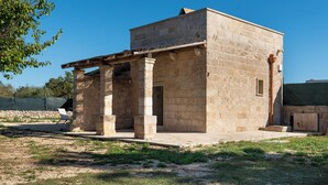 A stone building with a covered patio and a door. - Dimora Forticito (Marittima)