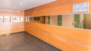 A hallway with wooden paneling, tiled flooring, and a sign on the wall. - 2-Room Apartment with Sea View Terrace, Balcony, and Air Conditioning (Cavalaire-sur-Mer)