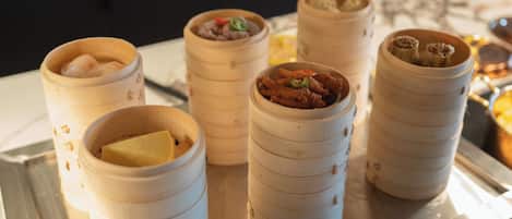 A buffet with various food items in bamboo steamers.