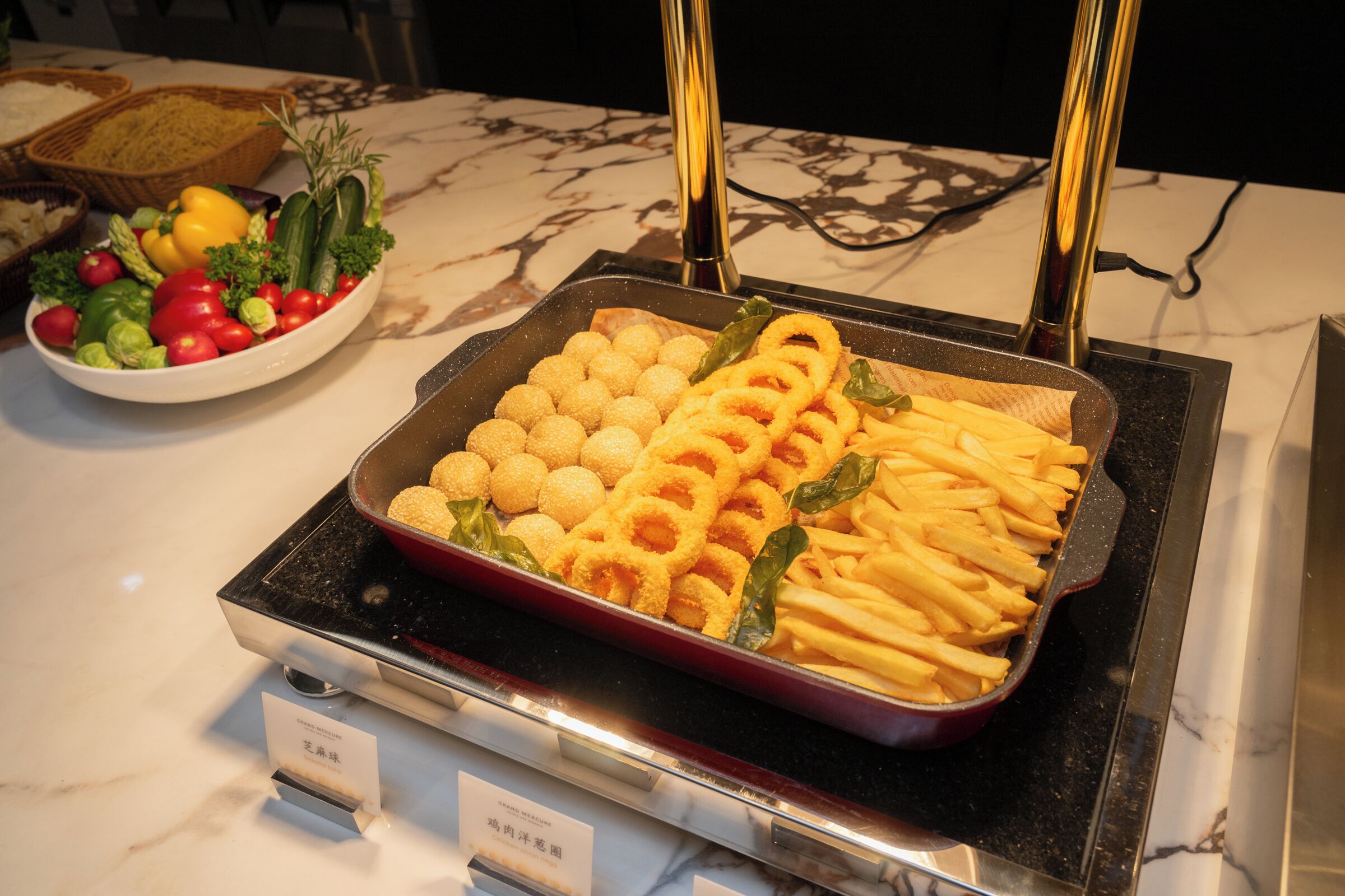 A buffet with various food items, including bread, salad, and fried foods.