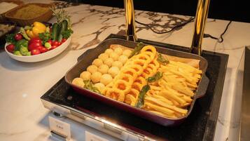 A buffet with various food items, including bread, salad, and fried foods.