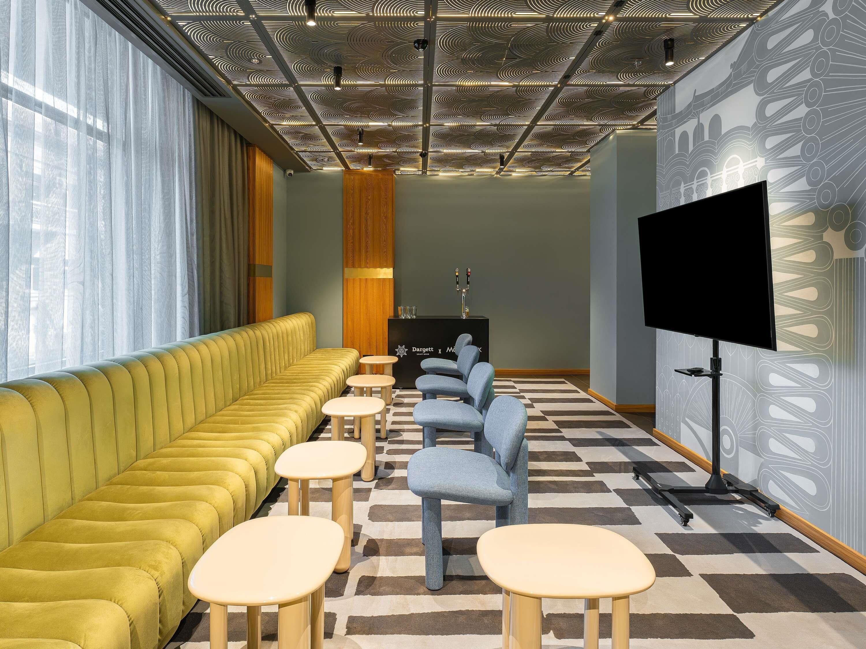 Un espace de détente moderne comprenant un canapé, des fauteuils et un téléviseur à écran plat.