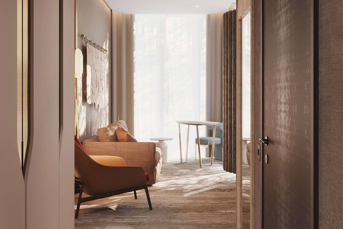 Una habitación de hotel con sofá, una mesita y una silla.