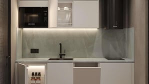 Une cuisine moderne équipée d’un four à micro-ondes Bosch, d’un évier encastré et d’une hotte en acier inoxydable.