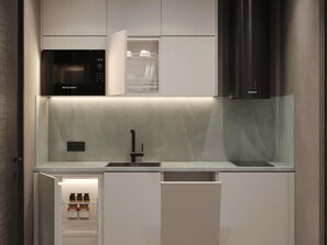 A modern kitchen with a Bosch microwave, a built-in sink, and a stainless steel range hood. - Mövenpick Yerevan (Yerevan)