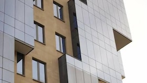 Un immeuble à plusieurs étages doté d’une architecture moderne, avec des balcons et une enseigne « MOVENTICK » bien visible.