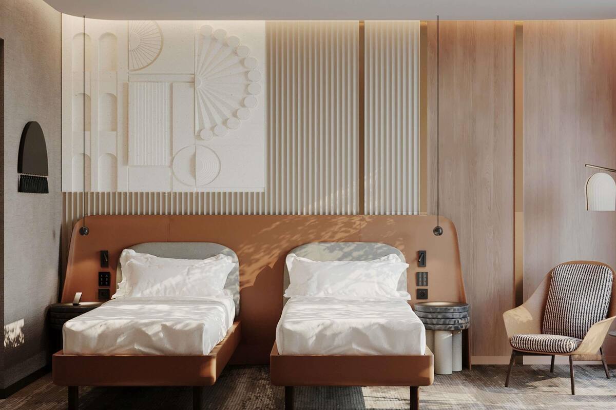 A modern hotel room with two beds, a large wall-mounted artwork, a wooden panel wall, a round side table, and a patterned armchair.