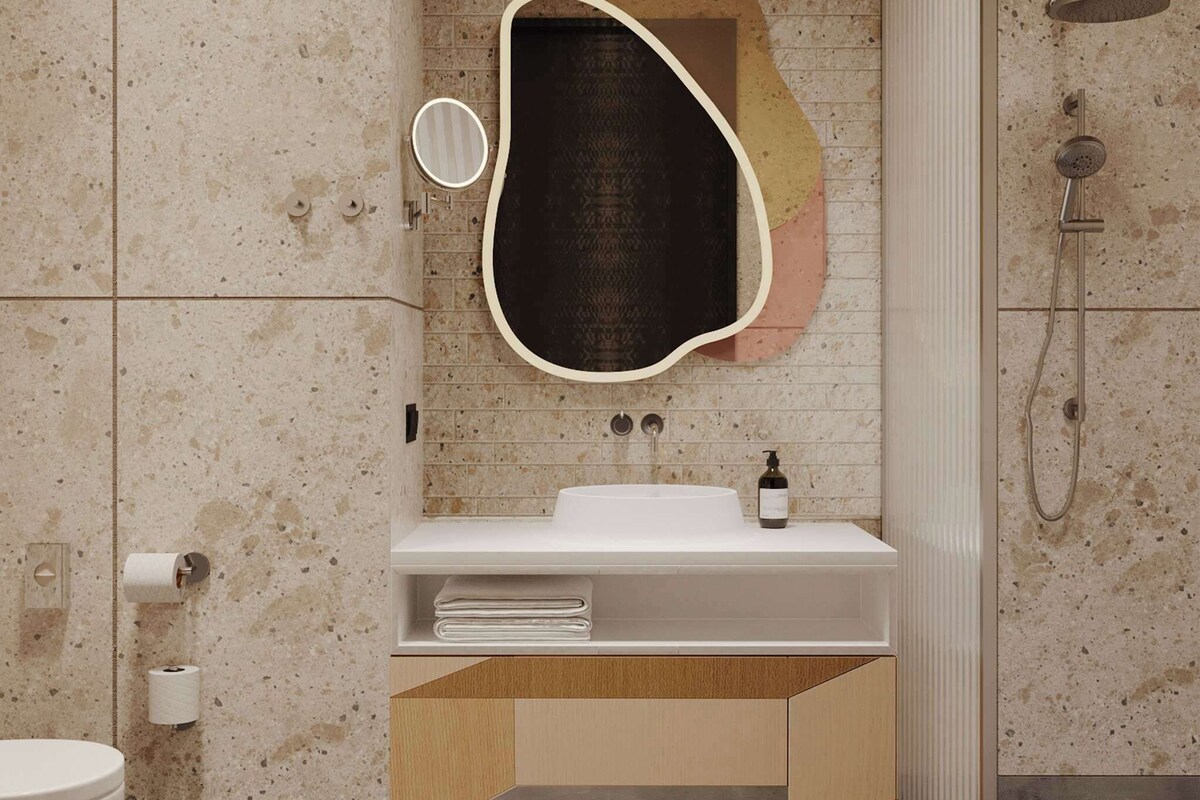 A modern bathroom with a freestanding sink, a mirror, and a shower.
