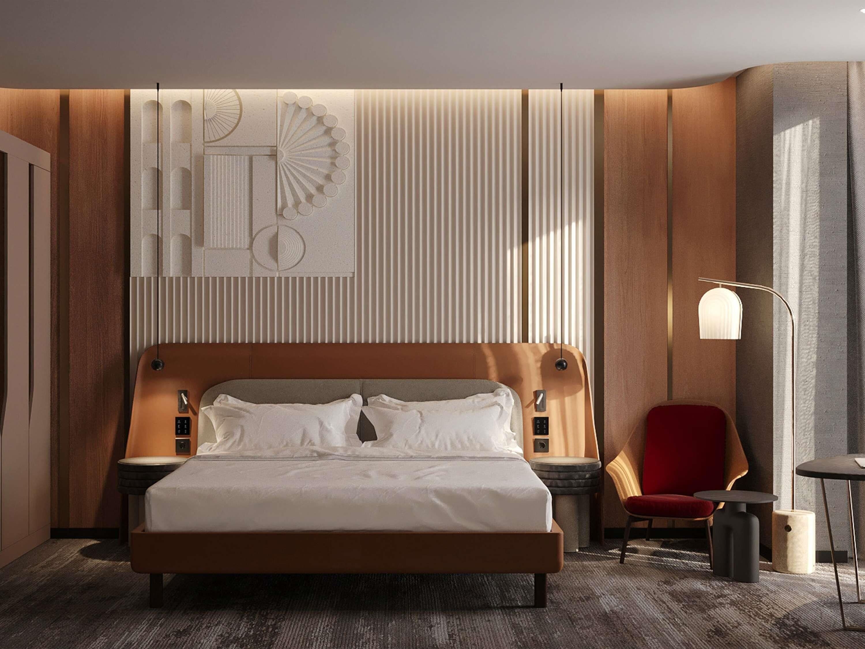 Una habitación de hotel moderna con una cama grande, una silla roja, una mesita de noche y un aplique de pared.