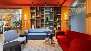 Een modern interieur met een blauwe bank, een rode fauteuil en een vloer met een patroon.
