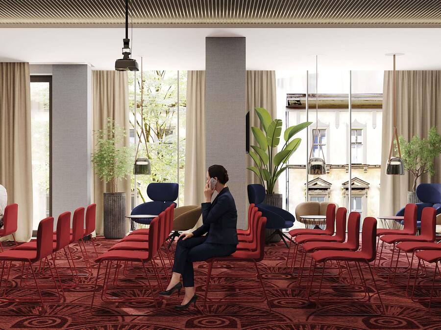 A hotel lobby with a seating area, a large plant, and a view of a building outside.