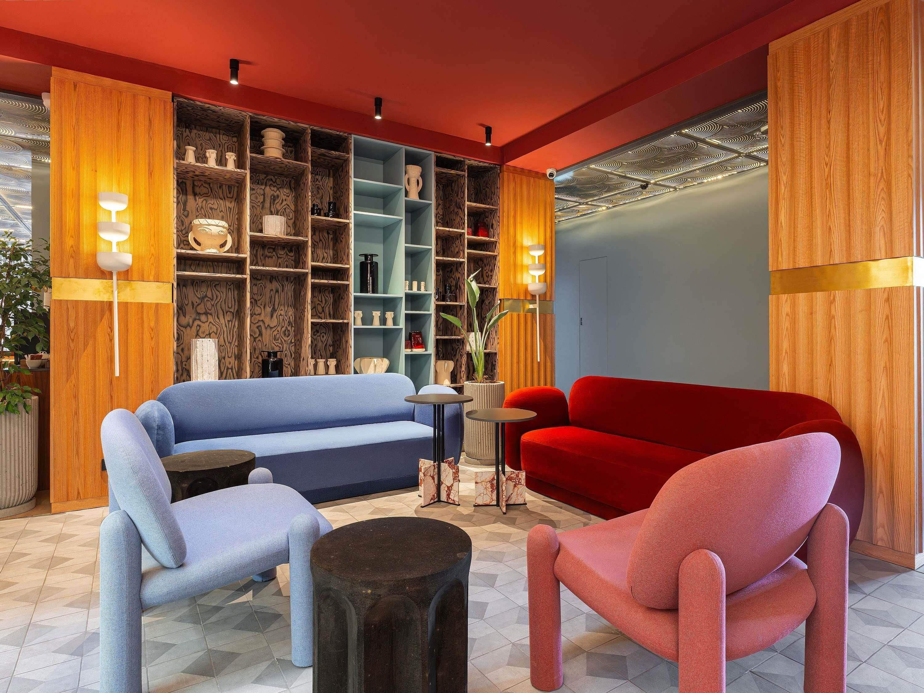 A modern living room with a blue sofa, a red sofa, and a round coffee table.