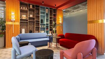 A modern living room with a blue sofa, a red sofa, and a round coffee table.