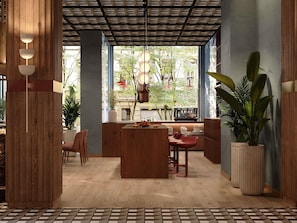 Un interior moderno con mobiliario de madera, una barra de café y ventanas amplias.