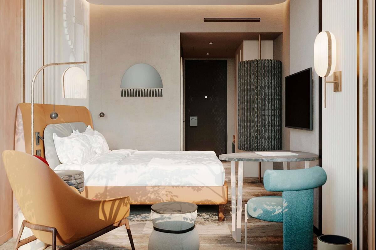 A modern hotel room with a bed, a sofa, a small table, and a TV.