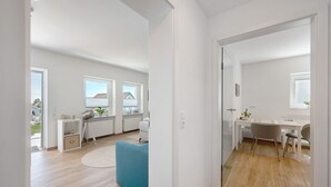 Un appartement moderne doté d’un coin repas, d’une cuisine et offrant une vue sur l’extérieur.