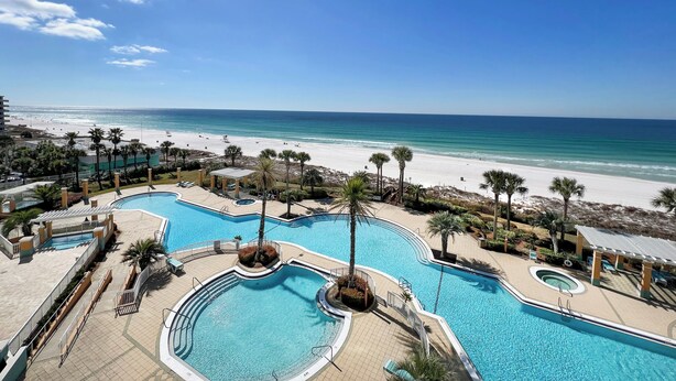 Un resort con diverse piscine e vista sulla spiaggia.