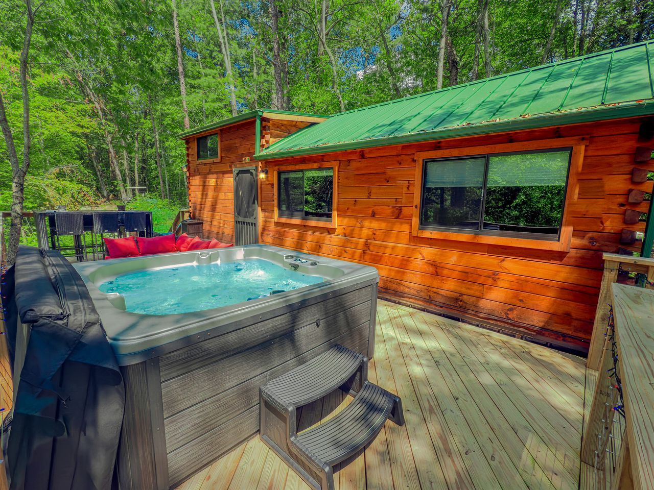 A wooden cabin with a hot tub and deck.