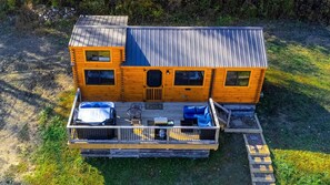 Eine Holzhütte mit einer Terrasse, einer überdachten Sitzecke und einer kleinen Veranda.