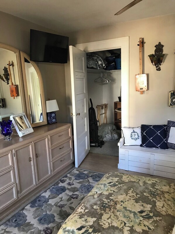 A bedroom with a bed, dresser, and a TV mounted on the wall.